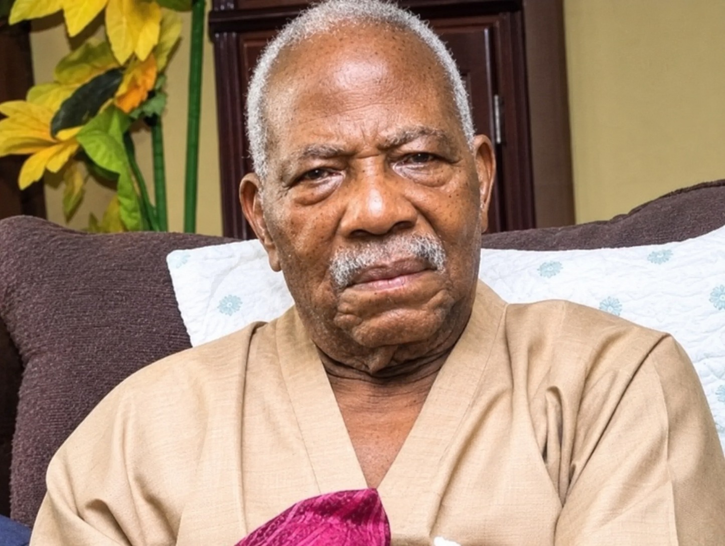 Portrait of Pa Reuben Famuyide Fasoranti seated in a beige traditional outfit.